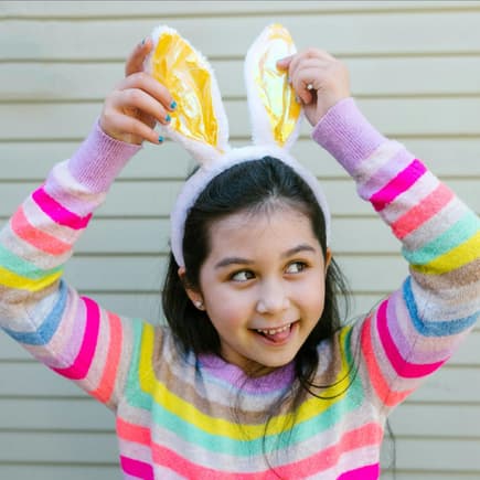 Ostergedichte machen gute Laune Ein Mädchen mit lustigen Osterhasenohren