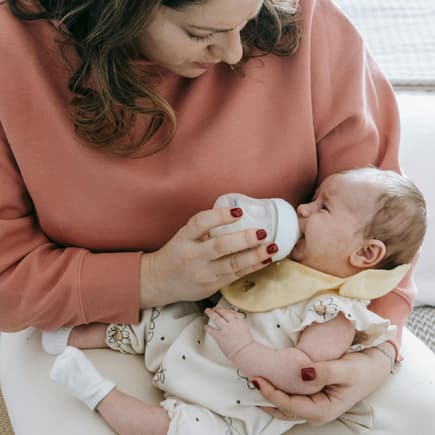 Oh je, mein Baby will die Flasche nicht! Ein Baby wird mit Flasche gefüttert.