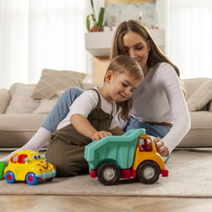 Jungs-Mamas müssen sich oft ungebetene Kommentare anhören. Mutter spielt mit ihrem Sohn auf dem Fußboden.