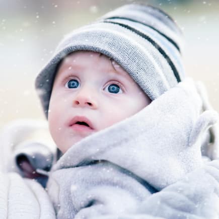 Winternamen haben einen zauberhaften Klang. Kleiner Junge staunt über Schneeflocken.