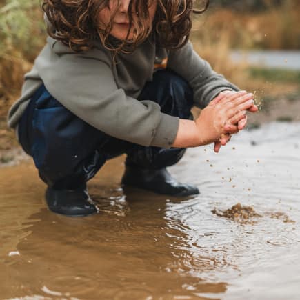 Kind spielt in einer Pfütze Kind spielt in einer Pfütze