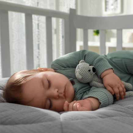 Dank frischer Luft schlafen viele Babys besser. Baby schläft in seinem Bettchen.