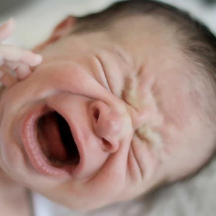 Achtung, eine Wärmflasche kann bei Babys zu üblen Verbrennungen führen. Baby schreit aus voller Kehle.