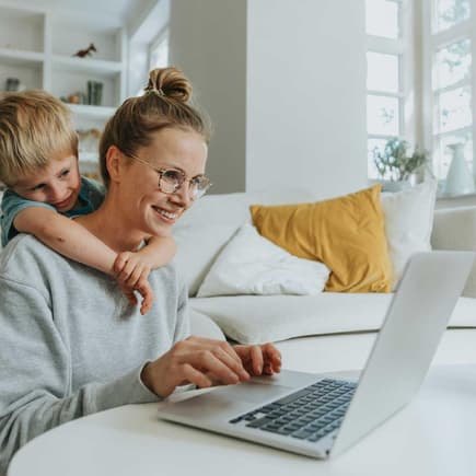 Immer mehr Mamas wagen den Sprung in die Selbstständigkeit. Mama mit Kind am Laptop.