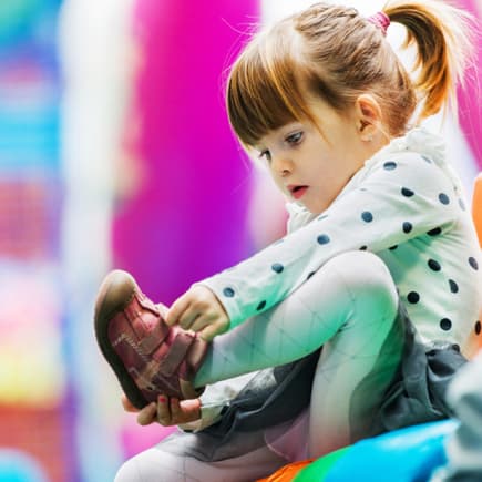 Das Anziehen der Schuhe ist für Kinder anfangs gar nicht so leicht.