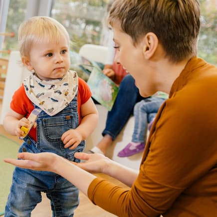 Etwa ein Drittel aller Kinder in Deutschland besuchen eine Kita oder Tagesmutter. Erzieherin mit Kindern in der Kita.
