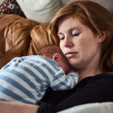 Kleine Gesten können Neu-Mamas super entlasten. Mama schläft mit Baby auf ihrem Bauch.