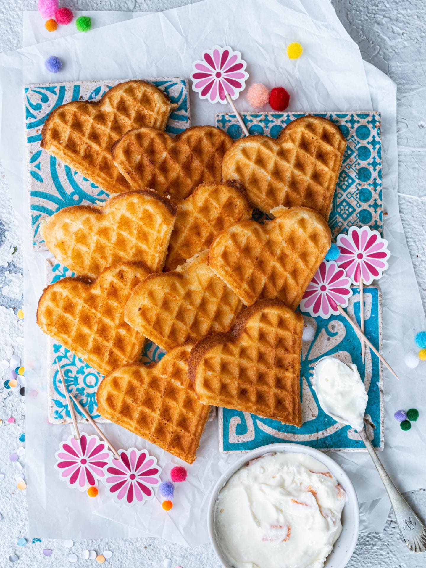 Fantakuchen-Herzwaffeln sehen hübsch aus und können einfach aus der Hand gegessen werden. Fantakuchen-Herzwaffeln liegen schön drapiert auf dem Tisch.