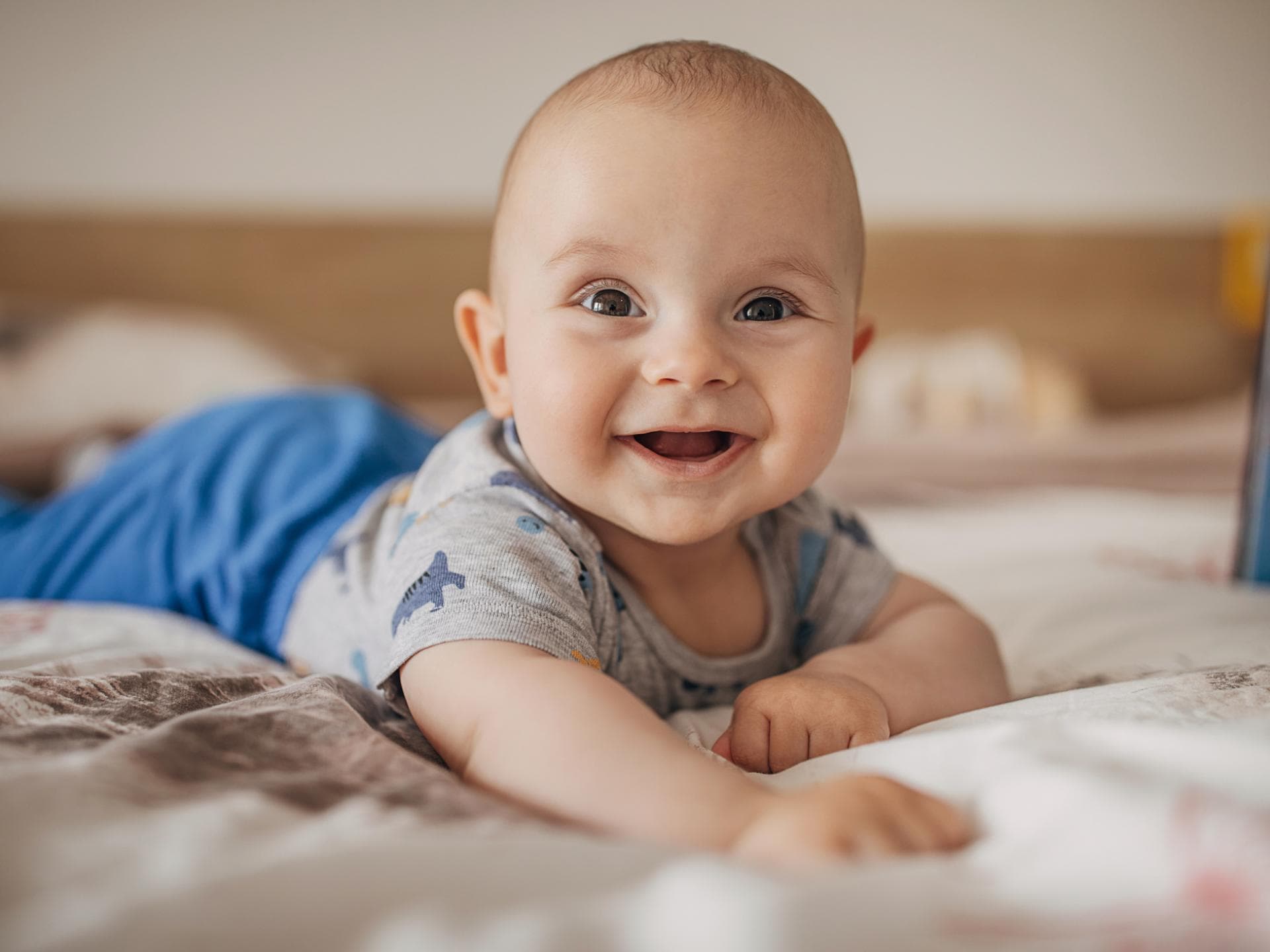 Ein Baby liegt lachend auf dem Bauch. Ein Baby liegt lachend auf dem Bauch.