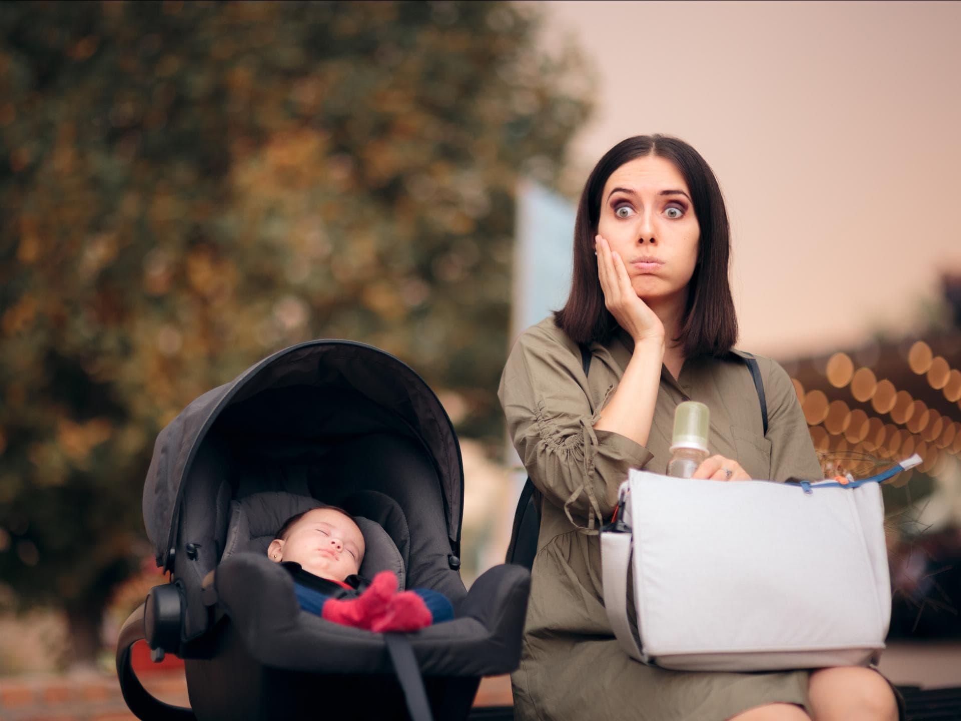 Vergessliche Mama sitzt neben ihrem Baby. Vergessliche Mama sitzt neben Baby in Babyschale.