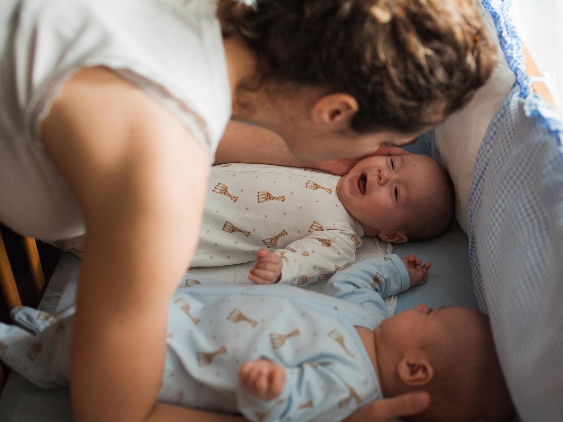 Mama legt zwei Babys ins Bett. Mama legt zwei Babys ins Bett.