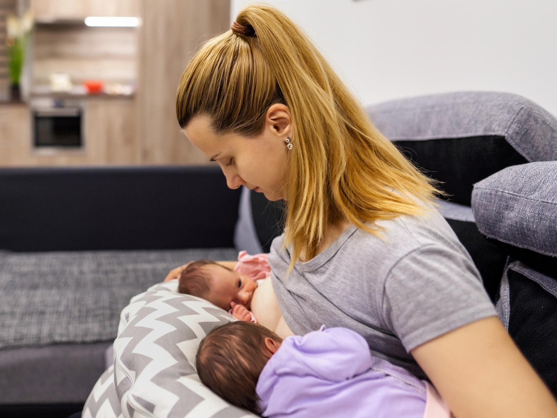 Mama stillt ihre Zwillinge auf Stillkissen Mama stillt ihre Zwillinge auf Stillkissen