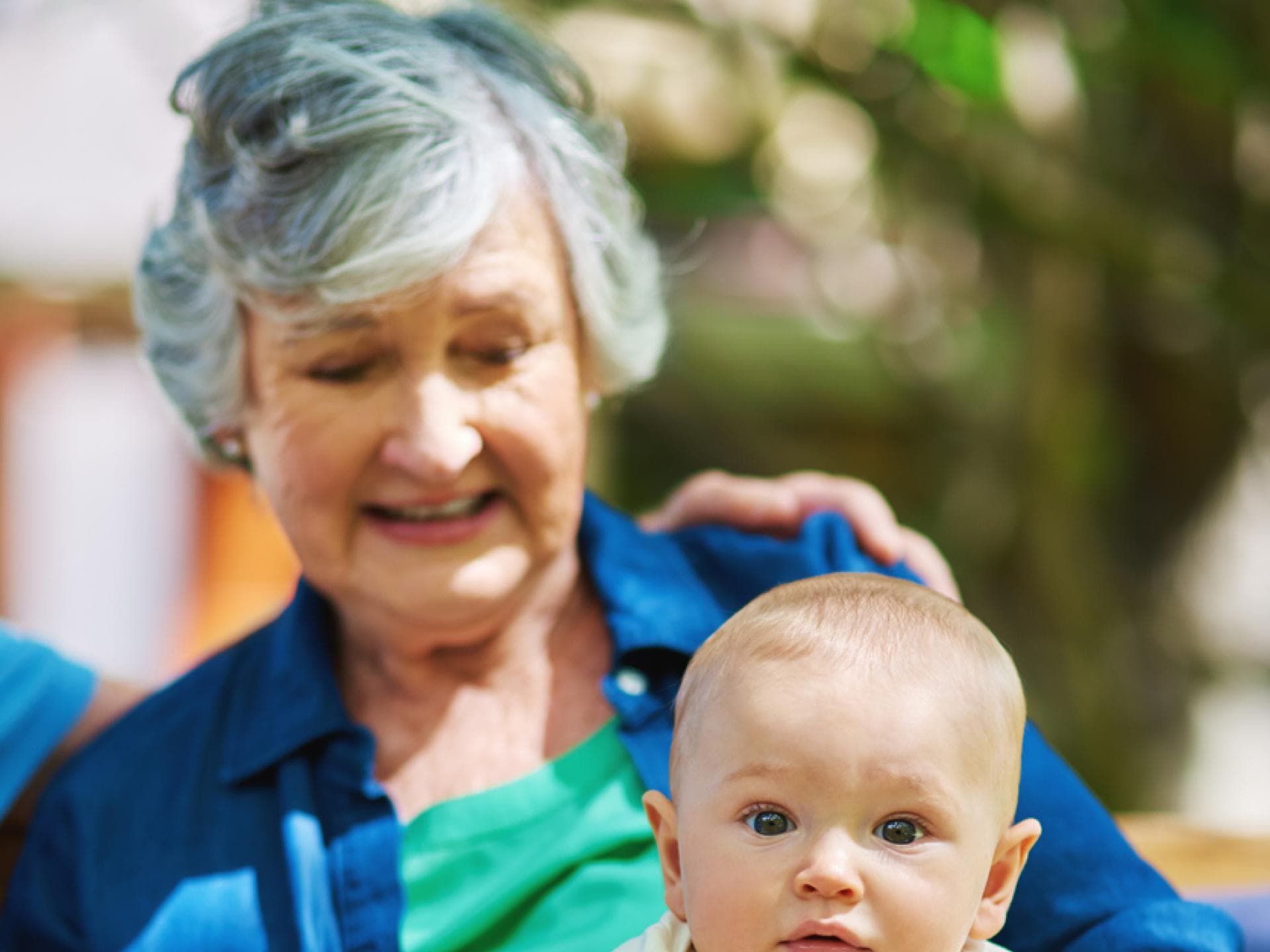 Baby sitzt bei Oma auf dem Schoss. Baby sitzt bei Oma auf dem Schoss.