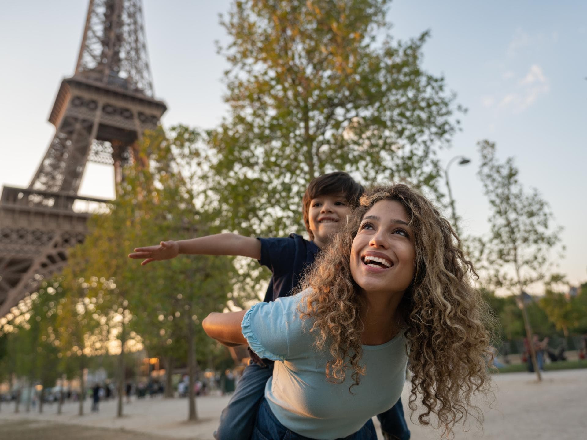 Eine Mutter und ihr Sohn spielen vor dem Eiffelturm in Paris, Frankreich. Eine Mutter und ihr Sohn spielen vor dem Eiffelturm in Paris, Frankreich.