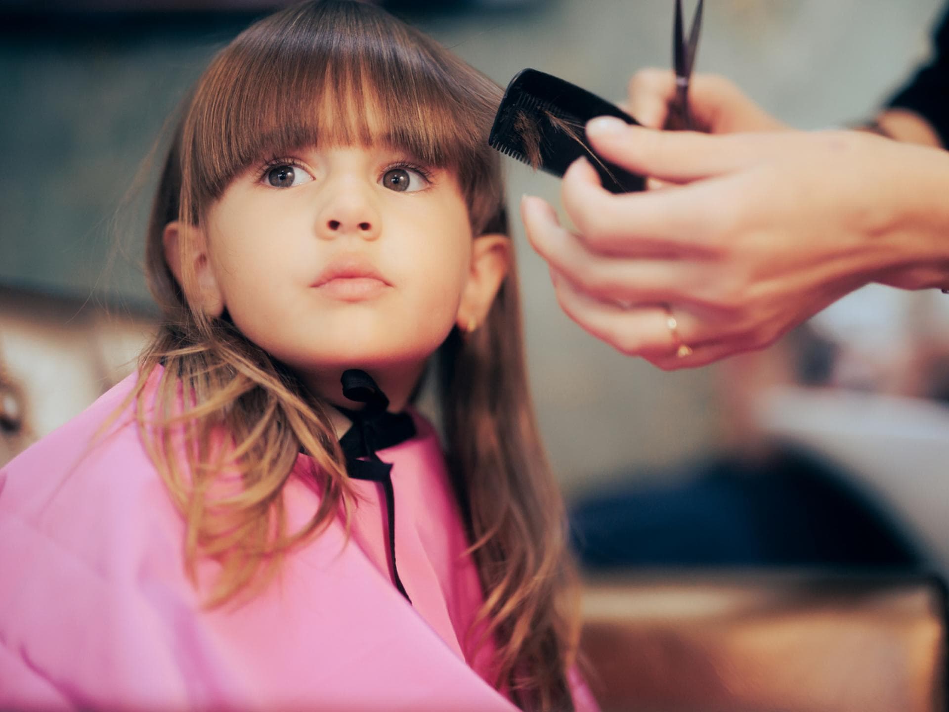 Pony schneiden beim Kind? Könnt ihr mit unseren Tipps leicht selber machen. Einem kleinen Mädchen mit langen haaren wird der Pony geschnitten.