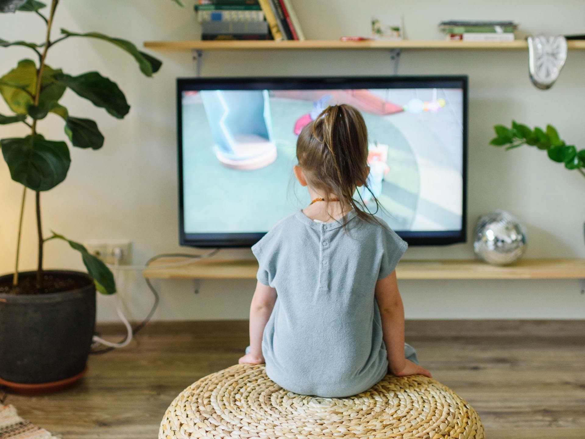 Kinderfilme auf Netflix: Das sind die aktuellen Highlights Ein kleines Mädchen guckt Fernsehen.