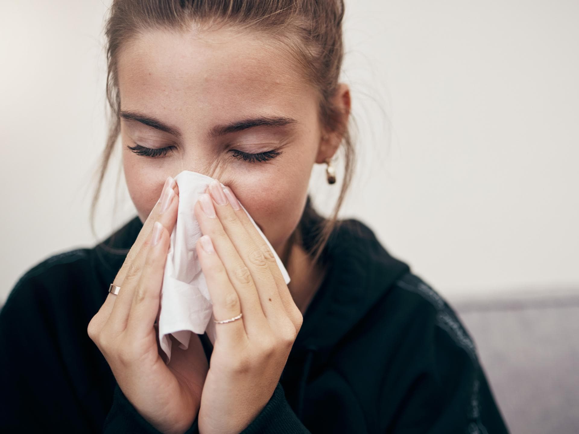 Auf der Toilette sollten sich Mamas nicht die Nase putzen. Frau putzt sich die Nase.