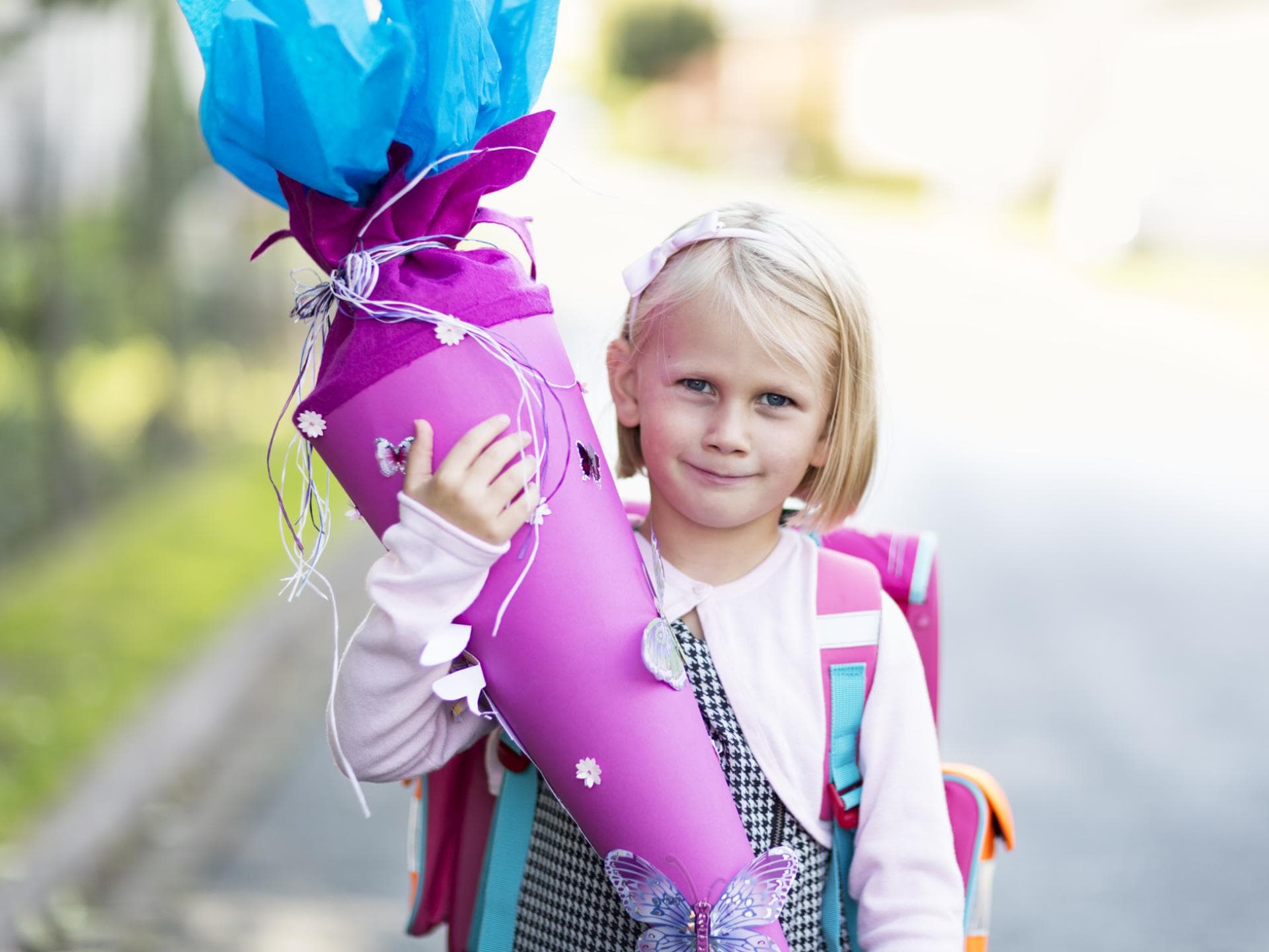 ABC-Gedichte zur Einschulung sind eine nette Geste von der Familie. Ein kleines Mädchen hält eine Schultüte in der Hand.