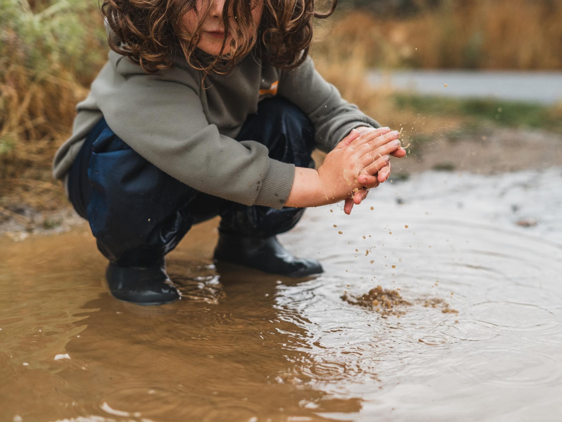 Kind spielt in einer Pfütze Kind spielt in einer Pfütze