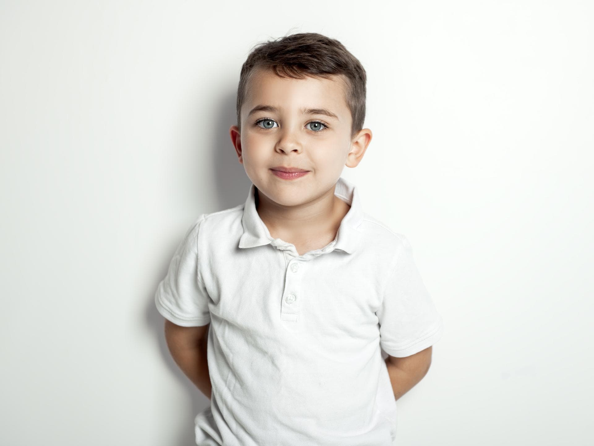 Ein klassischer Kurzhaarschnitt geht immer Ein kleiner Junge grinst leicht