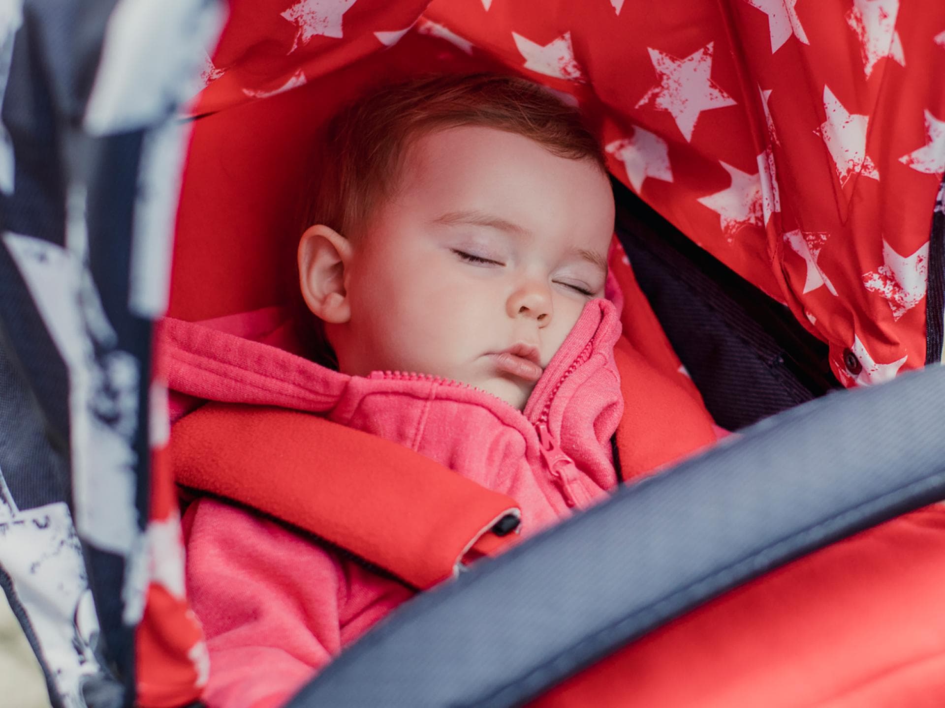 Frische Luft tut auch kranken Kindern gut – es gibt aber Ausnahmen. Kind liegt schlafend im Buggy.