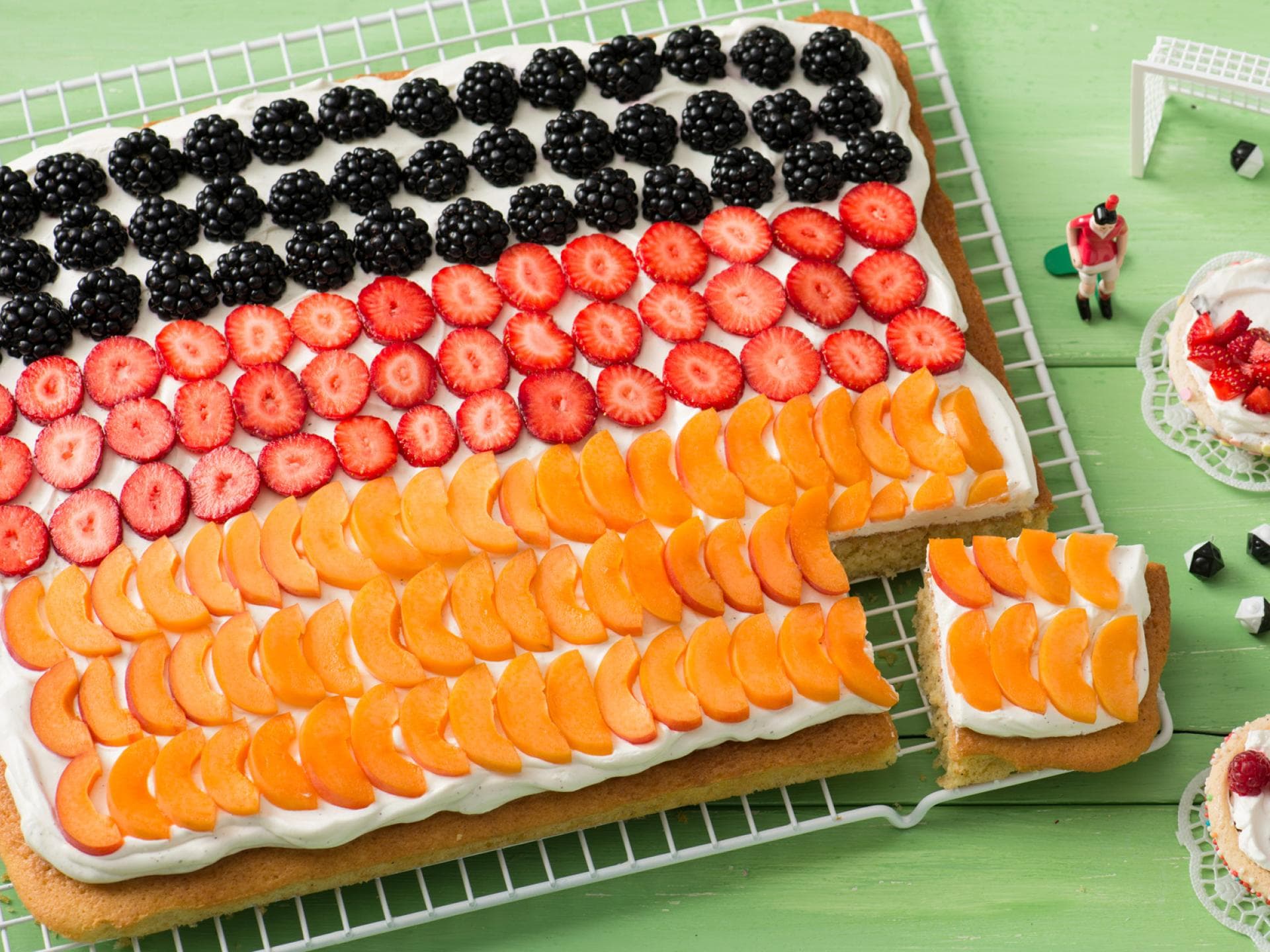 Mit Brombeeren, Erdbeeren und Pfirsichen dekoriert, stellt der Fantakuchen einen Fußballkuchen dar. Der Fatakuchen ist mit Brombeeren, Erdbeeren und Pfirsichen dekoriert.