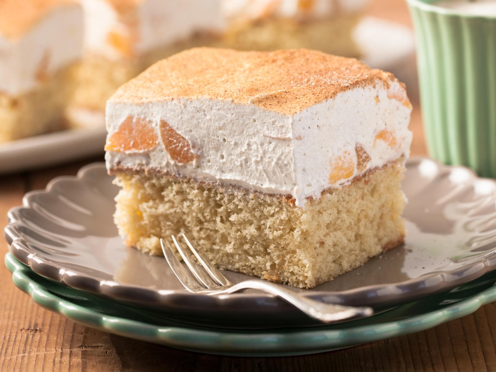 Fantakuchen mit Schmand ist luftig und lecker. Ein Stück Fantakuchen mit Schmand liegt auf einem Teller.