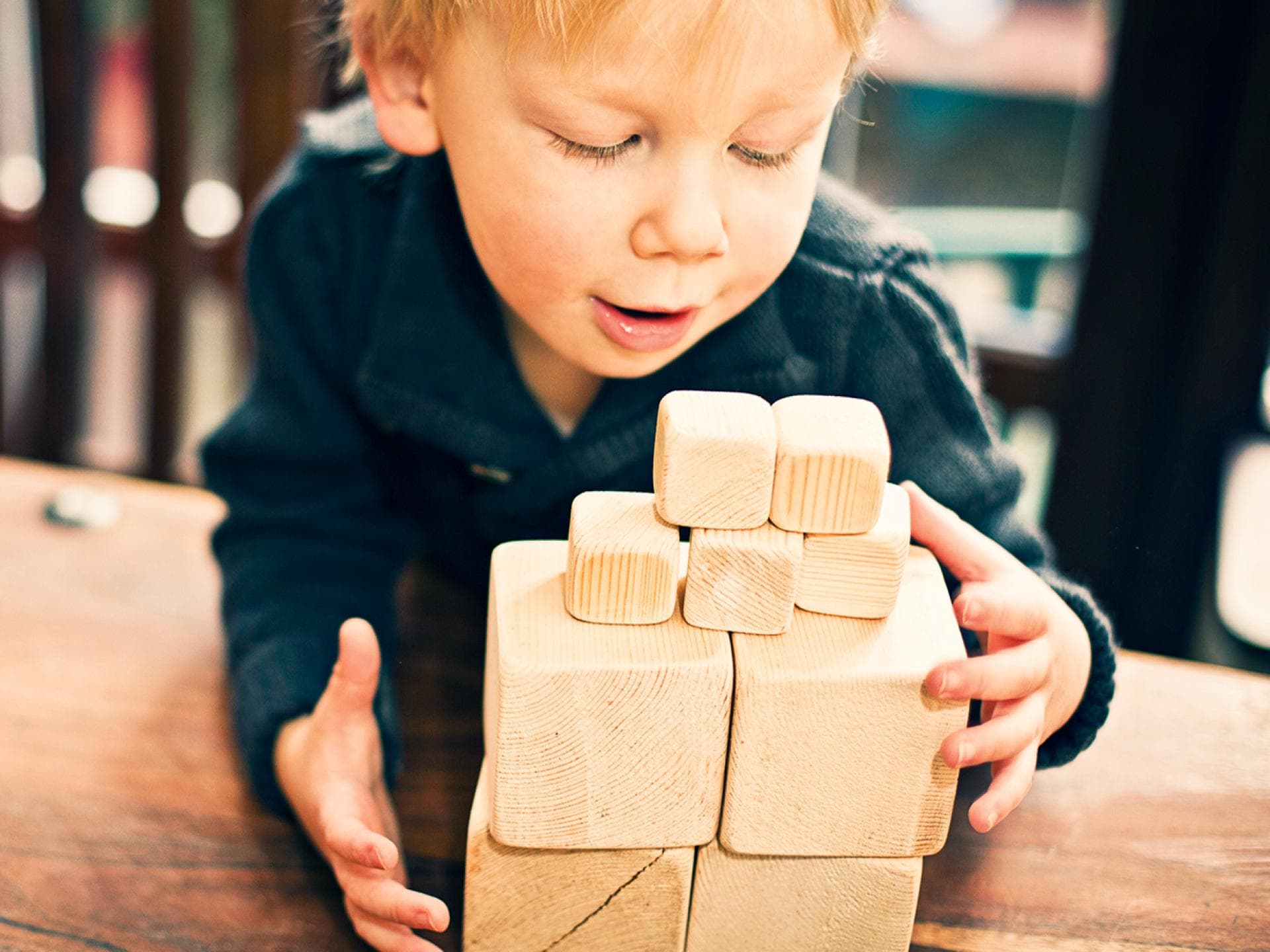Stein auf Stein: Bauklötze zählen zu den beliebtesten Spielzeugen überhaupt, fördern die Fantasie und die Kreativität. Kind mit Holzbausteinen
