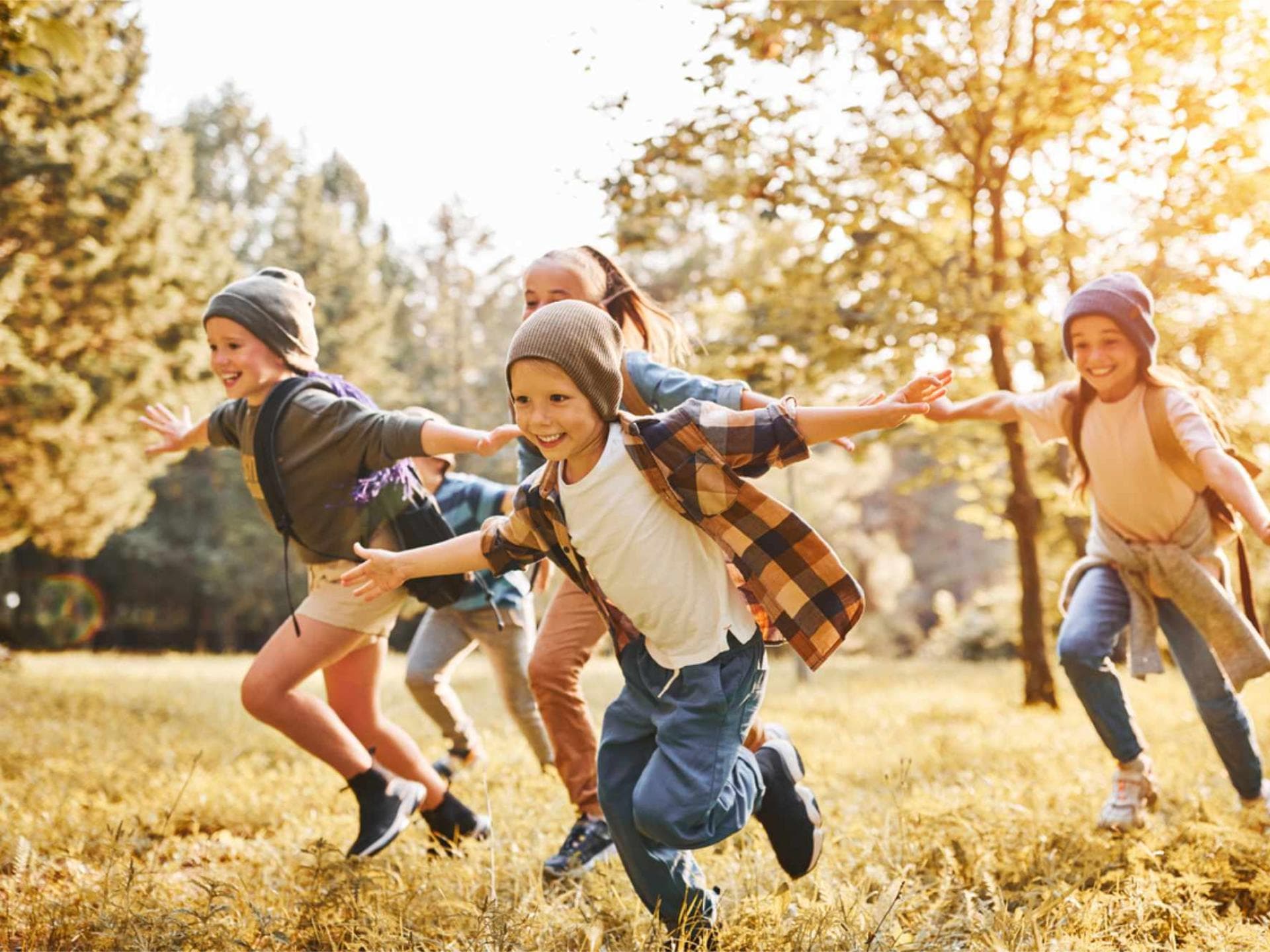 Wohl alle Kinder freuen sich über eine Schnitzeljagd! Selbst wenn es draußen kühler wird ... Kinder laufen fröhlich über eine herbstliche Wiese.