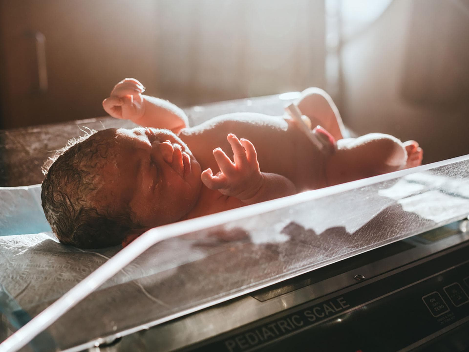 Das Geburtsgewicht beim Baby hängt nicht wirklich mit der Gewichtszunahme der Mama in der Schwangerschaft zusammen. Neugeborenes auf der Waage.